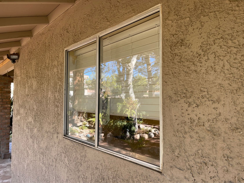 Same Las Vegas sliding window after professional hard water stain removal — crystal clear glass showing garden view