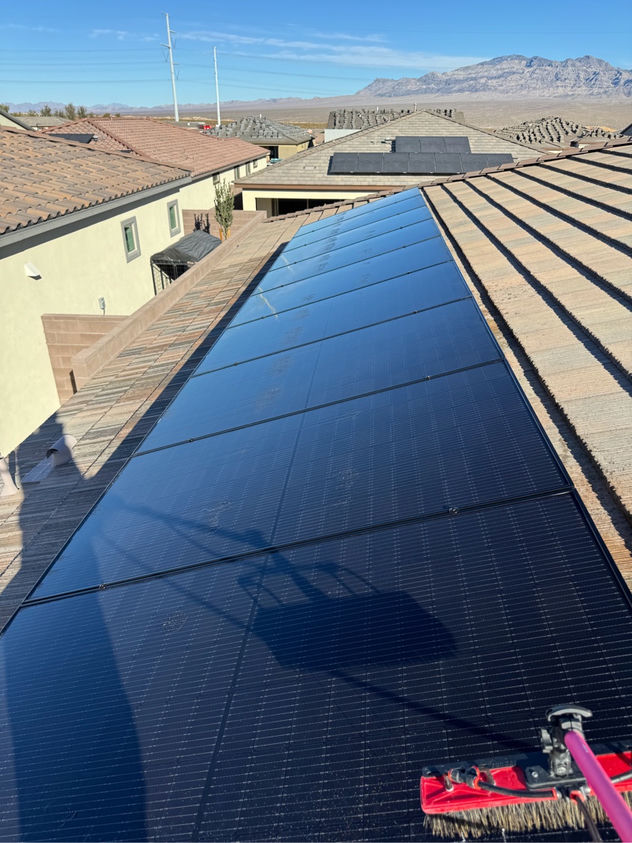 Freshly cleaned residential solar panels gleaming on a Las Vegas rooftop with Red Rock Canyon mountains visible in the background