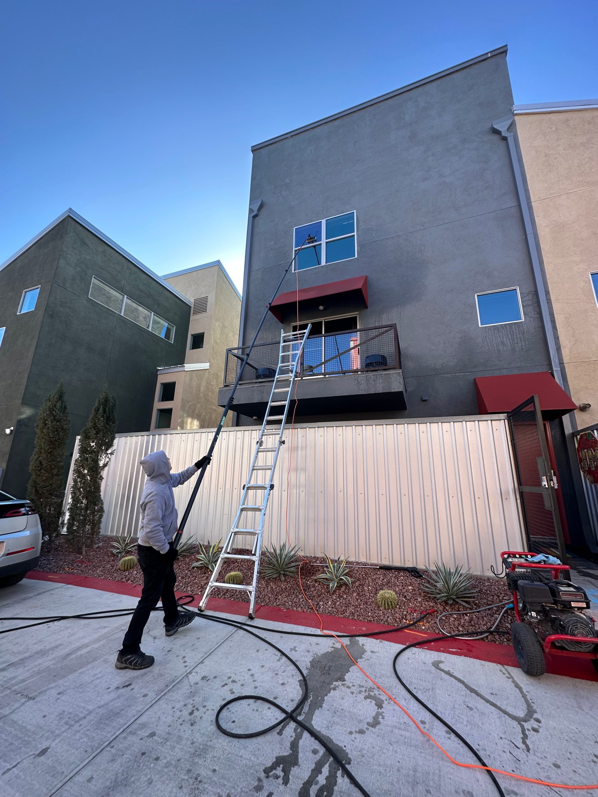 Three-story North Las Vegas home with exterior windows being professionally cleaned by Neon